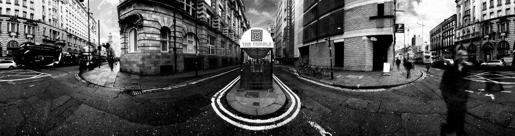 black and white 360 panorama looking at the entrance to the temple of convenience pub. The entrance is in the centre and Oxford road extends on either side with people and cars motion blurred